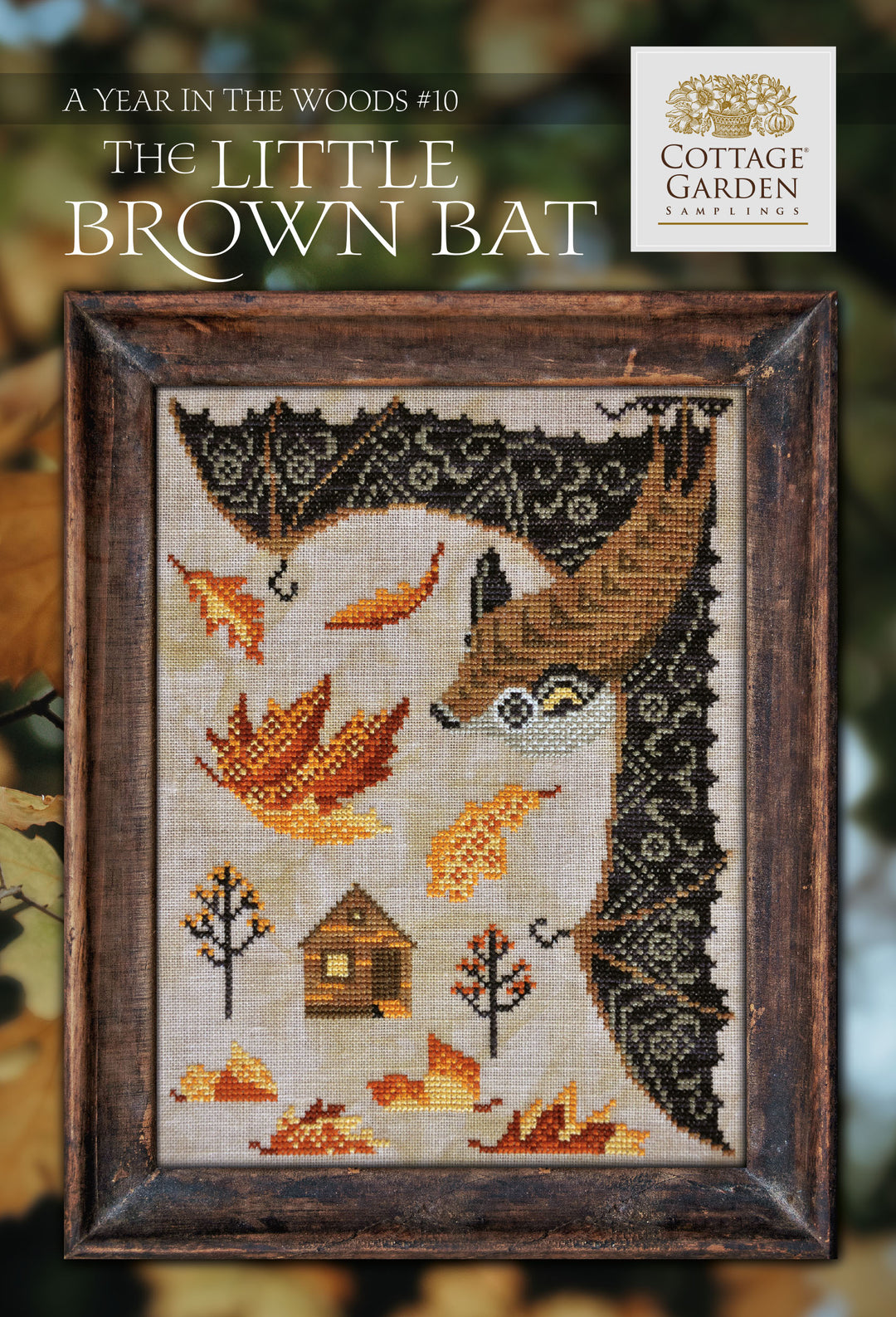Cross stitch pattern for 'The Little Brown Bat' depicting a design with a bat, leaves, and a cottage, in a frame, with the text 'A Year in the Woods #10' and the Cottage Garden Samplings logo.