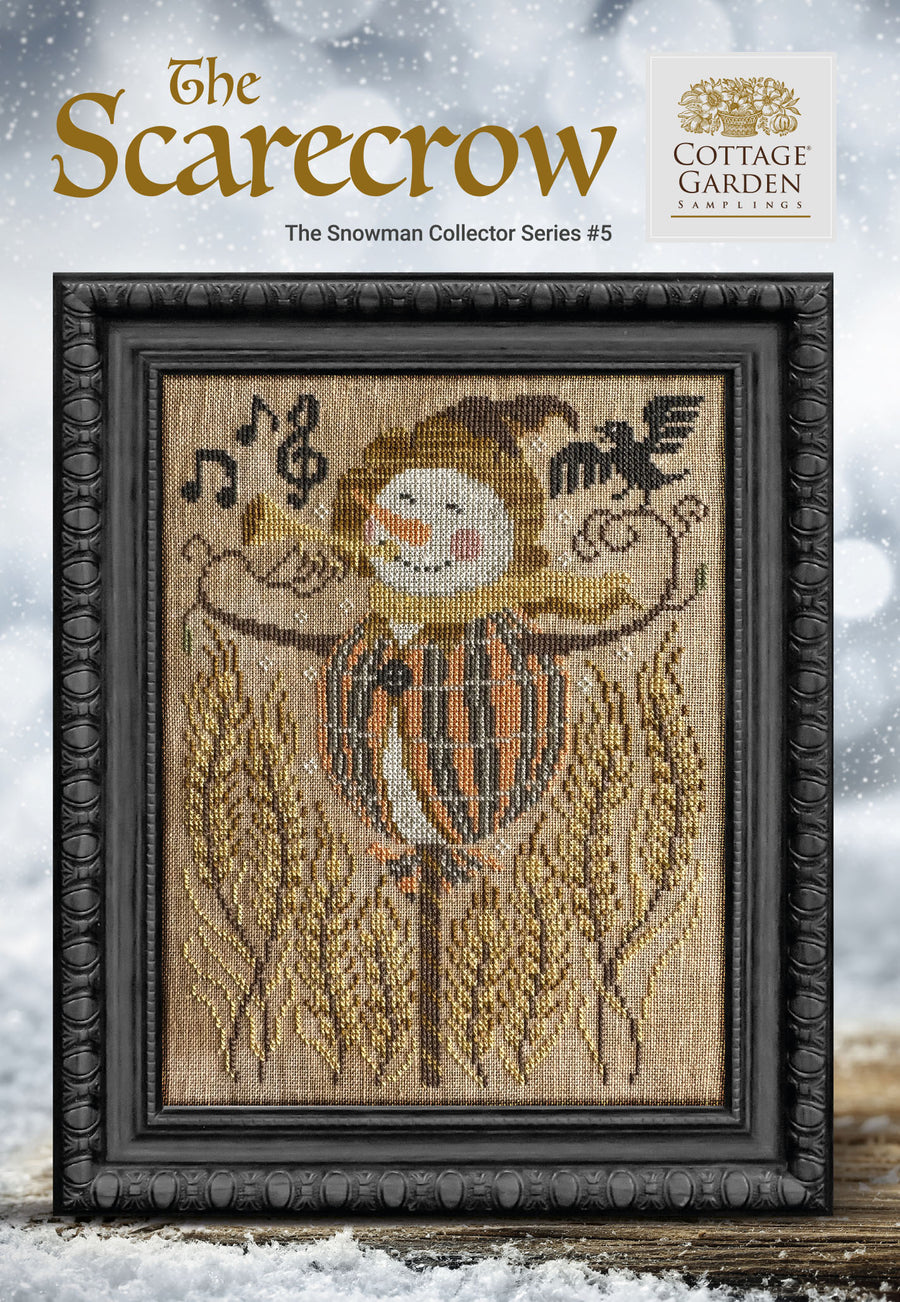 Framed cross-stitch pattern of a scarecrow with a snowy background