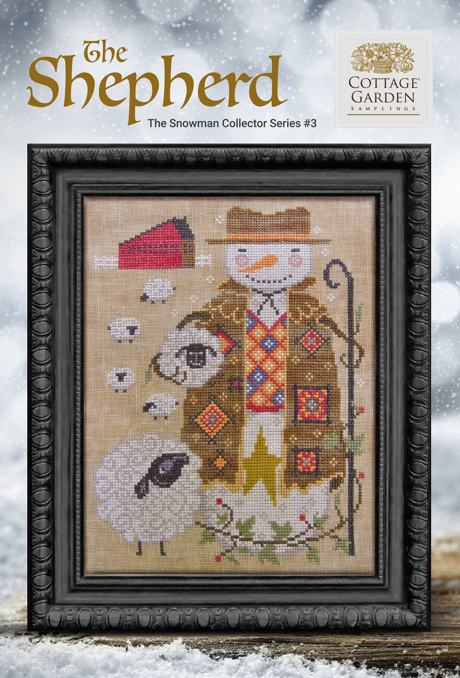 Framed cross-stitch pattern of a snowman and sheep with 'The Shepherd' and 'Cottage Garden' branding.