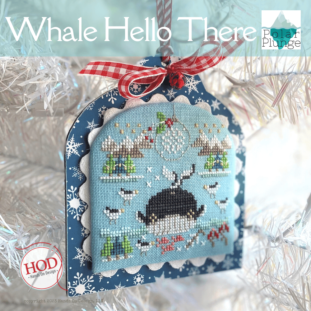 Decorative ornament with whale design and festive ribbon on a snowy background