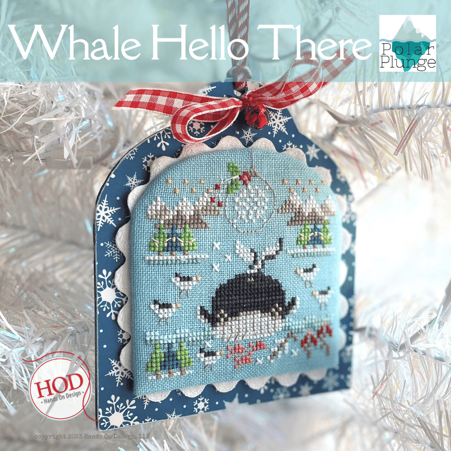Decorative ornament with whale design and festive ribbon on a snowy background