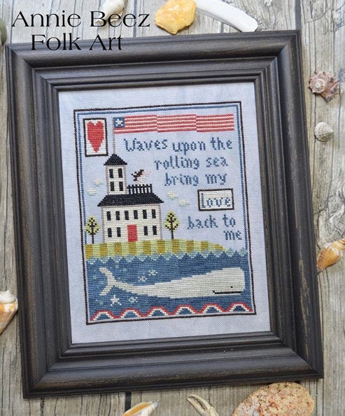 A needlecraft canvas with a patriotic theme, featuring a house, a lighthouse, a whale, and a poem.