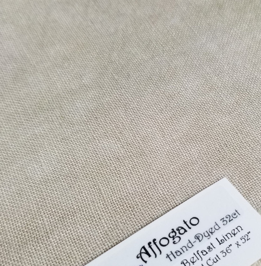 A swatch of beige, 100% linen fabric with a label showing the product details.