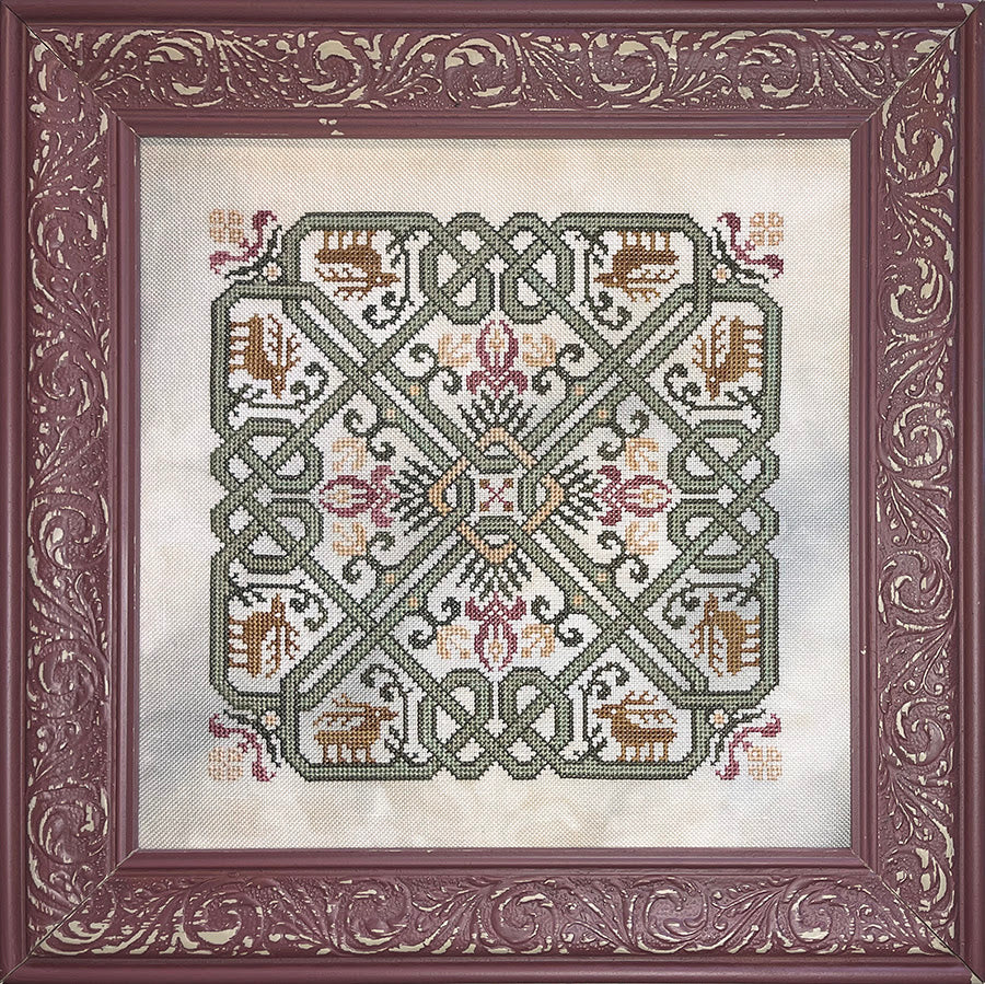 Decorative cross-stitched pattern with intricate design on fabric, framed by an ornate border.