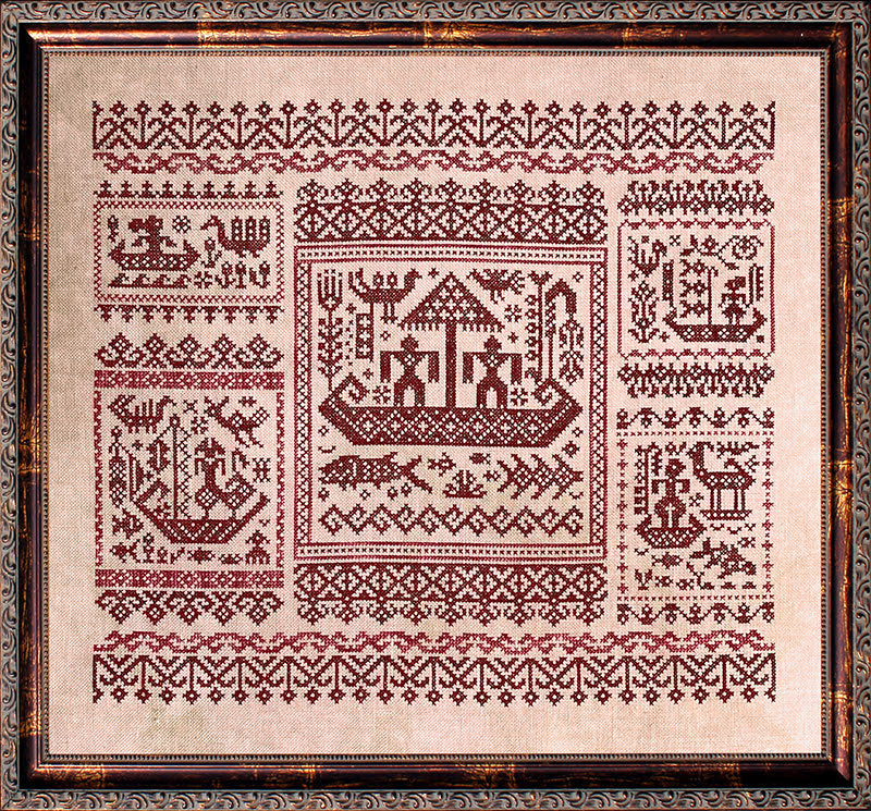 Decorative cross-stitched pattern on fabric with a wooden frame
