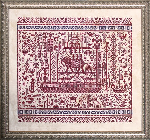 Framed cross-stitched pattern with red and blue designs on a beige background