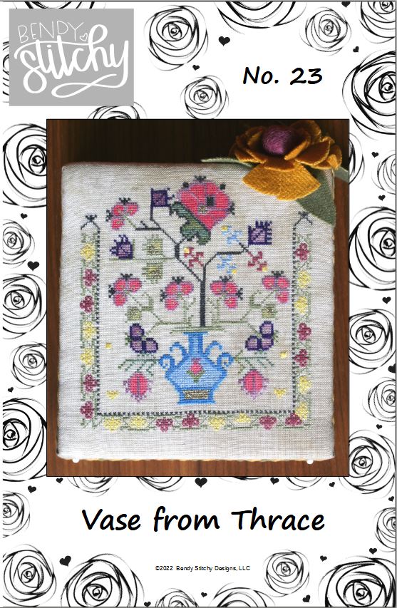 Cross-stitch pattern with floral design and vase, framed by decorative elements.